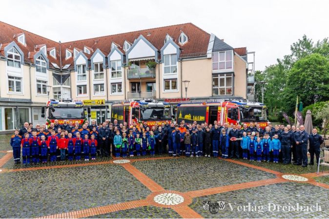 Gruppenfoto mit den drei neuen Hilfeleistungslöschfahrzeugen auf dem Marktplatz in Hattersheim.