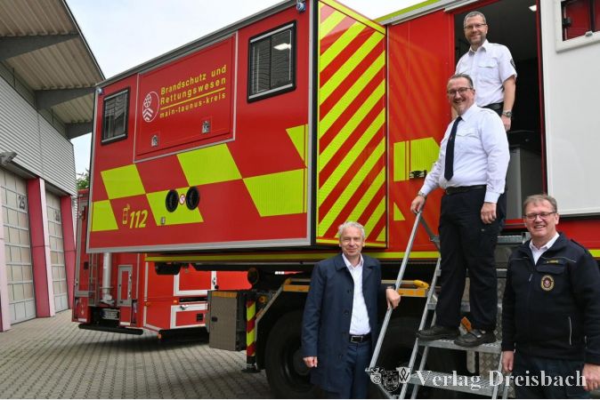 V.l.n.r.: Landrat Michael Cyriax, Martin Eden (Leiter der Technischen Einsatzleitung MTK), David Tisold (Stadtbrandinspektor Hattersheim) und Andreas Koppe (Leiter Amt für Brandschutz und Rettungswesen des Main-Taunus-Kreises) am neuen Container.