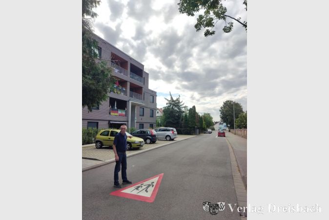 Der Erste Beigeordnete Franz Jirasek vor dem neuen Piktogramm in der Raiffeisenstraße.