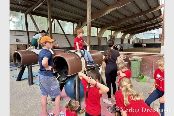 Die Kinder trainieren erst auf dem Turnpferd, bevor sie auf dem echten Tier sitzen dürfen.