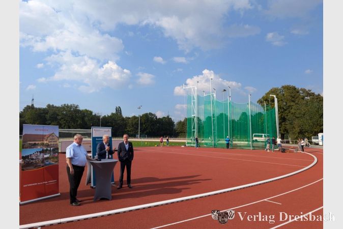 V.l.n.r.: Bürgermeister Klaus Schindling, Landrat Michael Cyriax und Landtagsabgeordneter Axel Wintermeyer. Im Hintergrund die neue Anlage für Speer- und Diskuswurf.