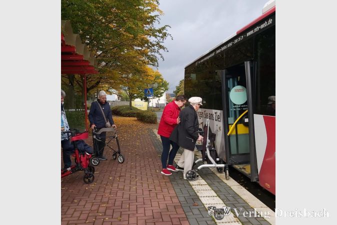 Hilfestellung beim Einsteigen mit dem Rollator in den Linienbus.