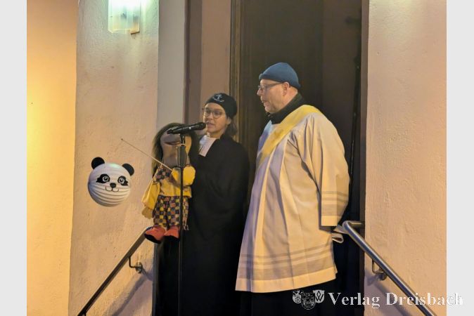 Pfarrerin Anne Möller und Diakon Jürgen Rottloff vor der evangelischen Kirche in Okriftel. Pfarrerin Möller erzählte mit ihrer Handpuppe eine Geschichte rund um eine kaputt gegangene Laterne.