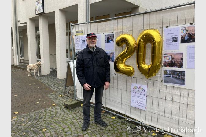 Wolfgang Bluhm neben der goldenen 20 am Bauzaun.