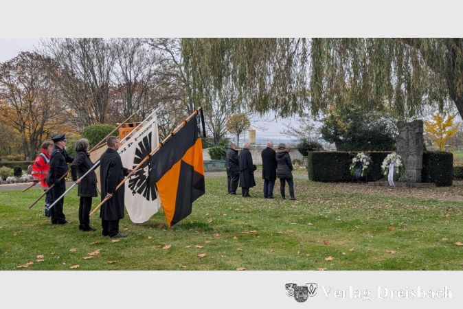 Standartenträger kirchlicher Gruppen flankieren den Bürgermeister und den Stadtverordnetenvorsteher Michael Kröhle, als sie den Gedenkkranz am Gedenkstein niederlegten.