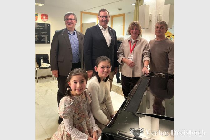 Amelié Mayumi Beyer (8) und Chloé Mayumi Beyer (11) am Flügel, dahinter v.l.n.r.: Dr. Frank Fichert, Bürgermeister Christian Seitz, Ingrid Franke und Diplom-Maler Yuriy Ivashkevich.