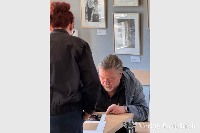 Armin Rohde beim Signieren der Anfang März versteigerten Fotografien.