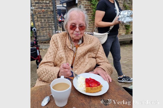 Anna Tauber lässt sich beim Maimarkt in Kriftel ein Stück Erdbeertorte schmecken.