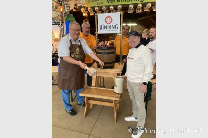 Wieder gelang Bürgermeister Klaus Schindling (links) der Fassanstich mit einem Schlag. Rechts Bernd Kraft, Vertreter der Radeberger Gruppe, die das Bierfass gespendet hatte. Dahinter Alexander Nöll (mit Paul-Leopold auf dem Arm), von der Kelterei Nöll, ebenfalls ein Sponsor des Festes.