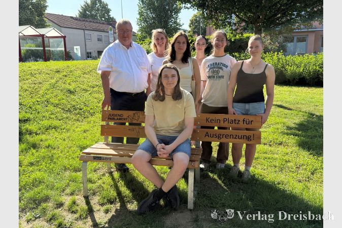 Bürgermeister Klaus Schindling (links) und die städtische Beauftragte Myriam Jung (2.v.l.) mit aktuellen und ehemaligen Mitgliedern des Jugendparlaments bei der Einweihung der neuen Sitzbank.