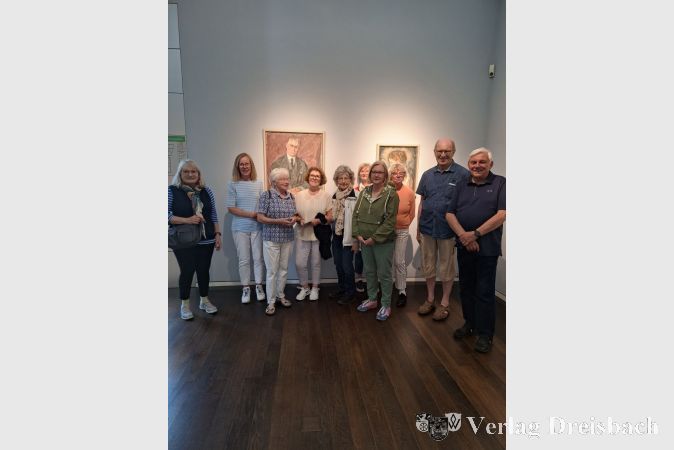 Die Teilnehmerinnen und Teilnehmer des Kulturforums-Ausflugs im Museum vor Portraits von Sidney und Jenny Brown.