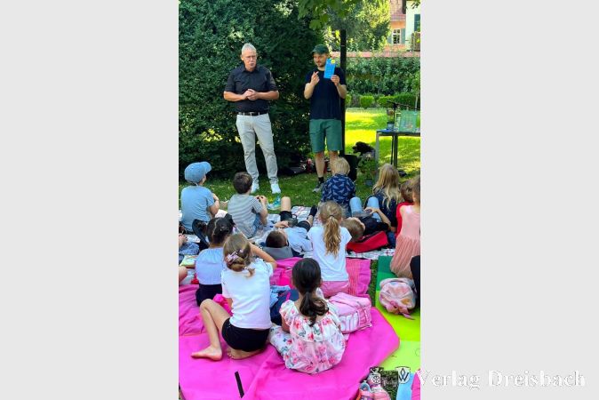 Stadtverordnetenvorsteher Georg Reuter (links) und Autor Jörg Bernardy begrüßten die Kinder im Bürgergarten.