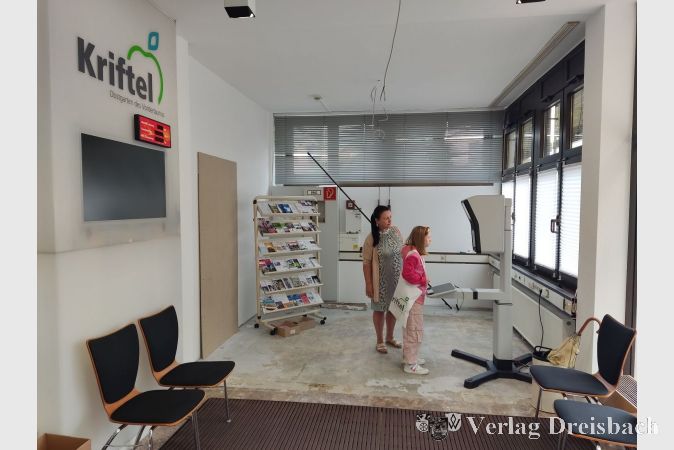 Christiane Franz, Leiterin des Bürgerservice, im Rohbau des vergrößerten Eingangsbereiches. Sie erklärt einer Praktikantin das Fototerminal.