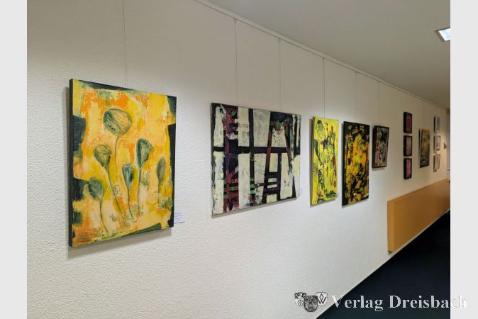 Die Werke der beiden Künstlerinnen sind bis zum 12. November im Rat- und Bürgerhaus zu sehen. Links im Vordergrund ist das Gemälde "Blumen grau auf gelb" von Susanne Bunte zu sehen, rechts daneben "Mal gerade" von Monica M. Stencl.