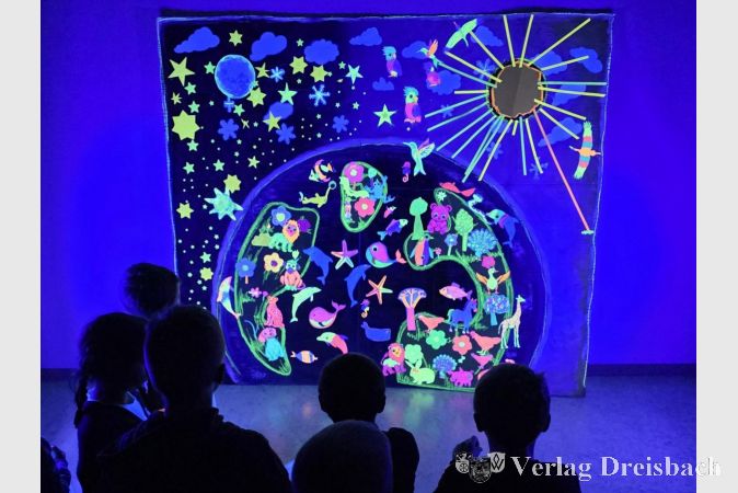 Staunend betrachteten die Kinder das von ihnen im Workshop geschaffene Schöpfungsbild, das im Schwarzlicht eindrucksvoll leuchtete.