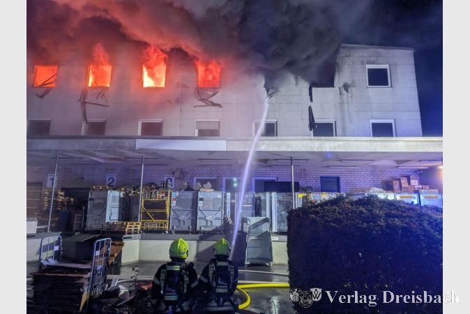 Die Brandbekämpfung erfolgt über mehrere Drehleitern und Außenangriffe, dichter Rauch steigt aus dem zweiten Obergeschoss auf.