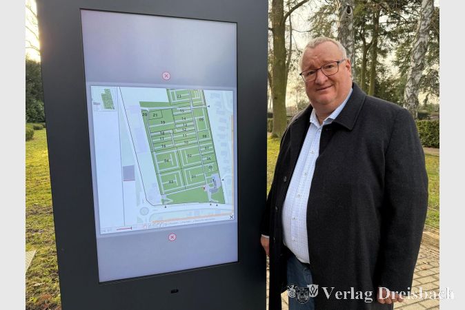 Bürgermeister Klaus Schindling an der ersten digitalen Stele auf dem Hattersheimer Friedhof.