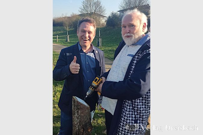 Foto: Gemeinde
Hermann Behrends mit dem Ersten Beigeordneten Martin Mohr beim Anschrauben des Spender-Schildes.