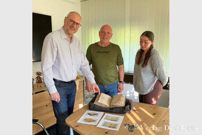 Foto: Gemeinde
Dr. Detlef Krause (links) zeigt im Rathaus Frank Bechstein und Lara Rötzsch vom Stiftungsrat das restaurierte Buch aus dem 17. Jahrhundert.