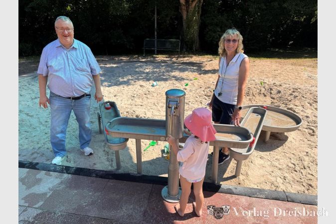 Foto: Stadt Hattersheim
Bürgermeister Klaus Schindling und Schwimmmeisterin Silke Schwenn mit einem Kind an der neuen Matschanlage.