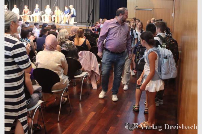 Foto: gus
Und los geht es: Eine der neuen fünften Klassen hat sich an der Stadthallen-Wand versammelt und besucht mit ihrem Lehrer nun erstmals den Klassensaal. Auf der Bühne trommelt dazu die Percussion-Gruppe.