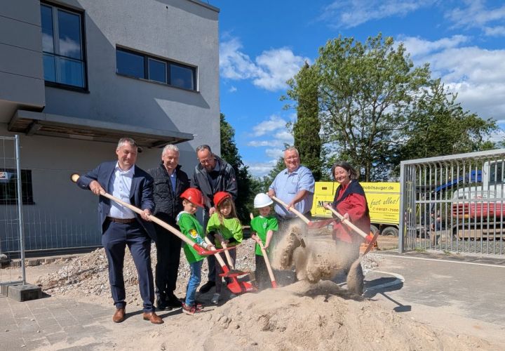 V.l.n.r.: Kreisbeigeordneter Axel Fink, Landrat Michael Cyriax, der Leiter des Hochbau- und Liegenschaftsamtes Peter Wesp, Bürgermeister Klaus Schindling sowie Schulleiterin Annette Richter-Bolderheij beim symbolischen Spatenstich, unterstützt von drei Schülerinnen und Schülern der Eddersheimer Schule.