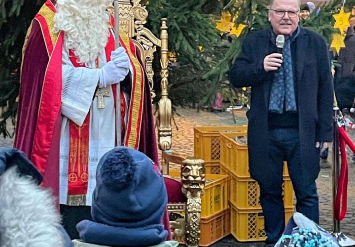 Nikolausbesuch: Pfarrer Friedhelm Meudt in der Rolle des Nikolaus verteilt gemeinsam mit Bürgermeister Bernd Blisch Weckmänner an die Kinder.